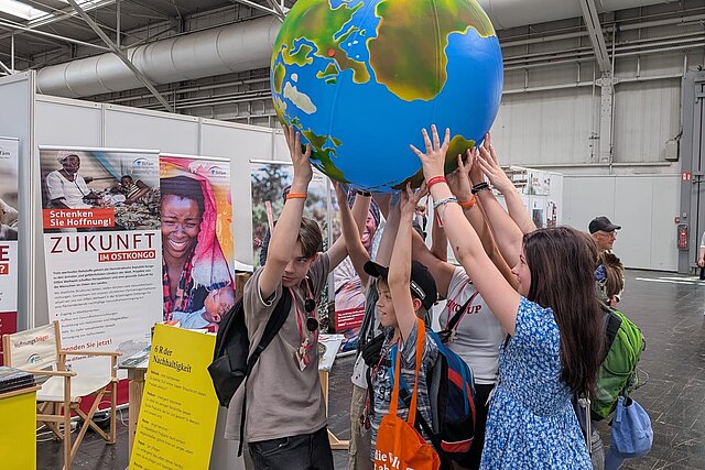 Interaktion mit einem Globus auf dem Kirchentag 2025.