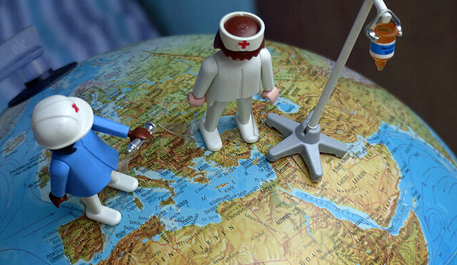 Playmobilmännchen stehen auf einem Globus